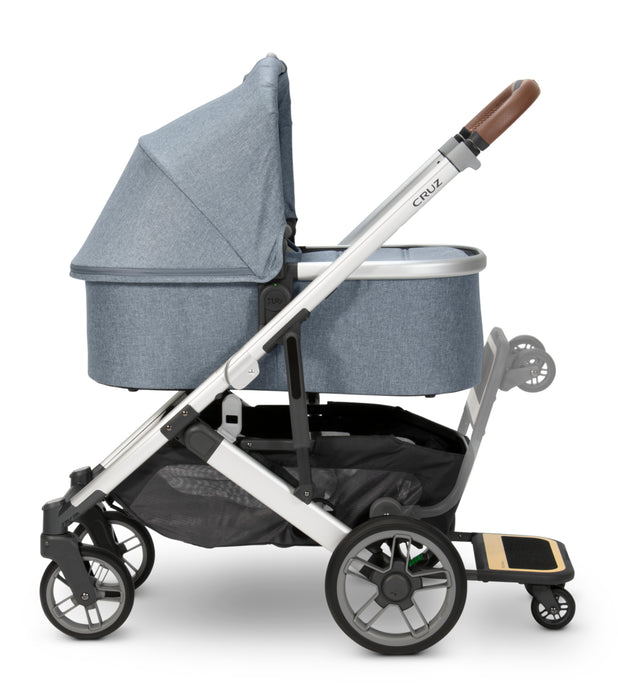 caption-Accessorize your UPPAbaby Cruz V2 Stroller - Shown with UPPAbaby Bassinet in Gregory and Piggyback Ride-on Board
