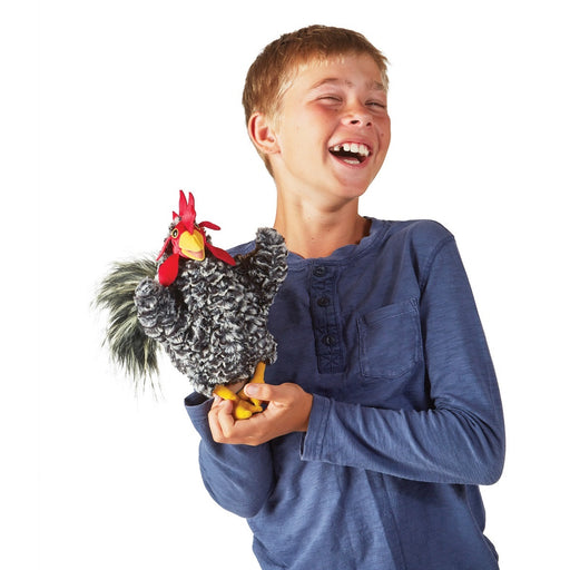 caption-Child holds Barred Rock Rooster Puppet with a laugh