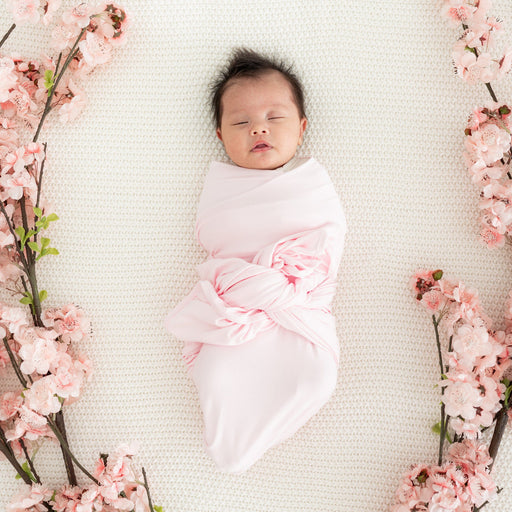 caption-Baby wrapped in Sakura pink bamboo swaddle blanket