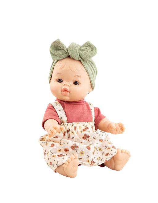 Baby doll with a floral dress and green headband on a white background