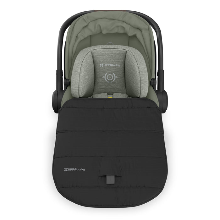 Green baby car seat with black footmuff on a white background