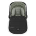 Green baby car seat with black footmuff on a white background