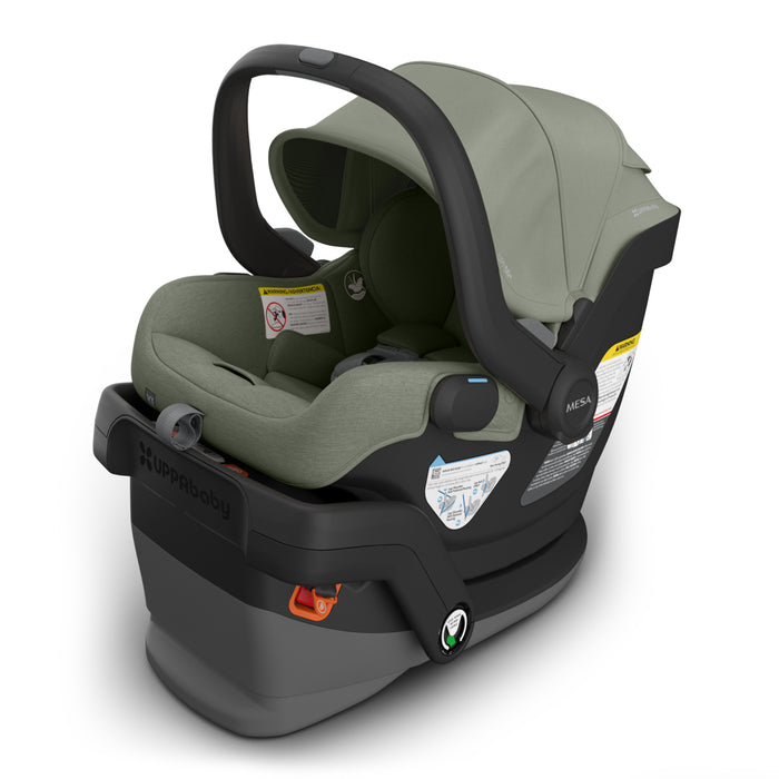 Baby car seat with green cover and black base on a white background