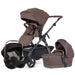 Brown and black stroller set with car seat and bassinet on a white background