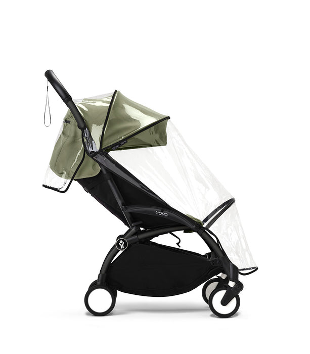 Black stroller with green canopy and clear rain cover on a white background