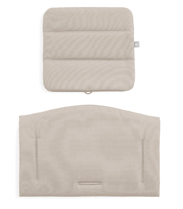 Two beige quilted pillows on a white background