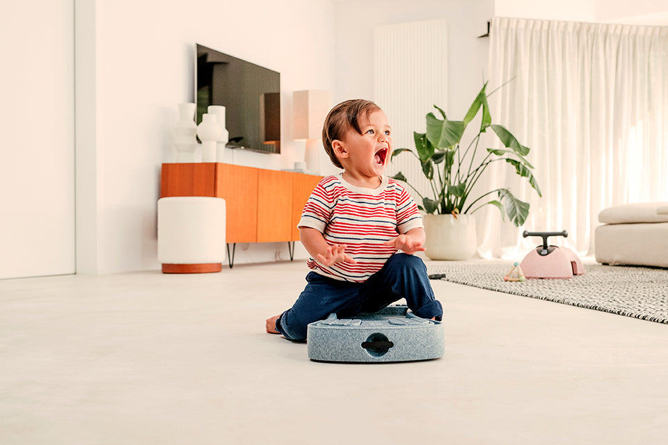 Child sitting on blue caster board ride on toy
