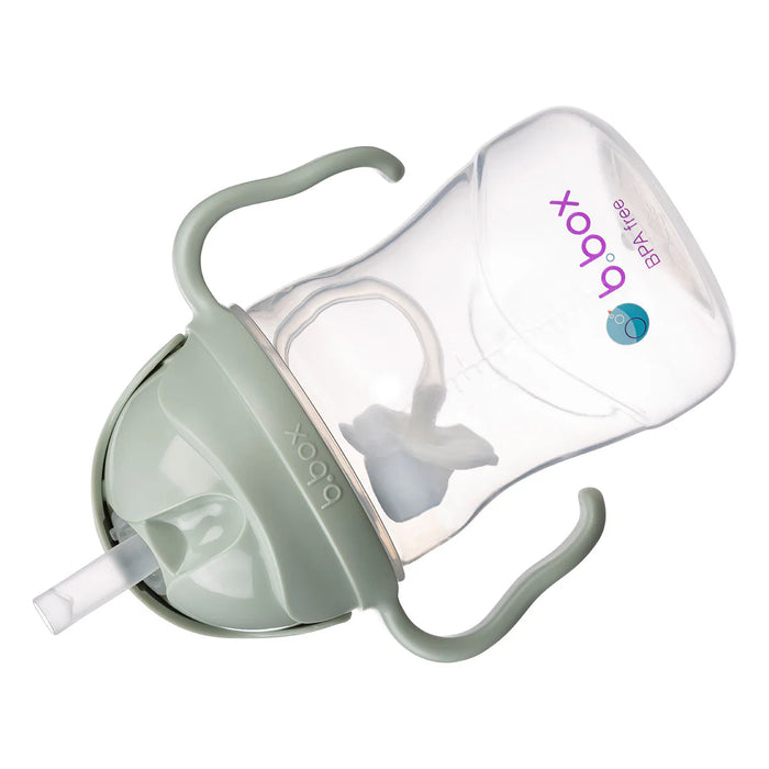 Baby bottle with green base and white top on a white background