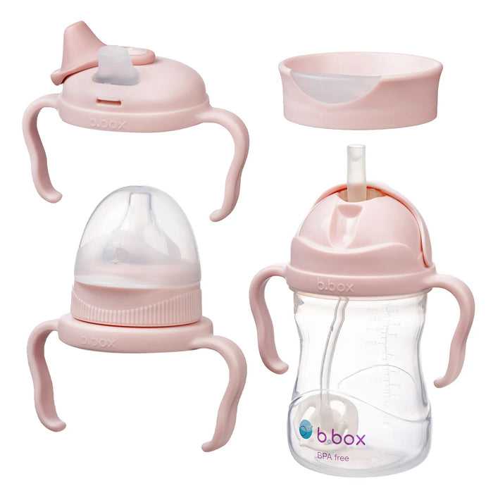 Set of pink baby bottles and sippy cups with b.box branding on a white background
