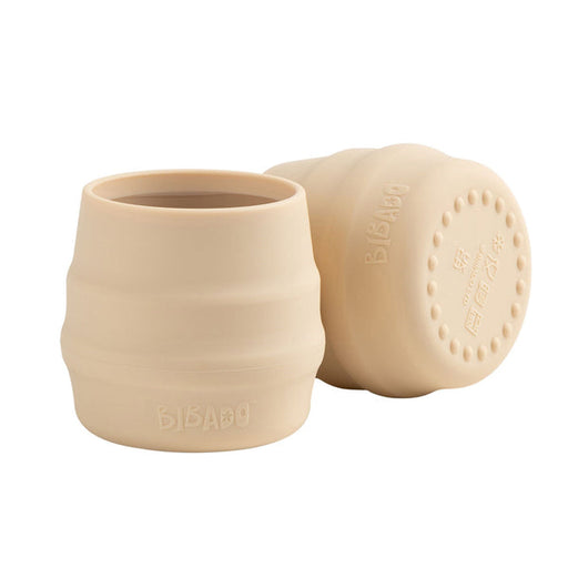 Beige silicone cup with lid on a white background