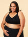 Woman wearing a black Cake bra and leggings on a beige background