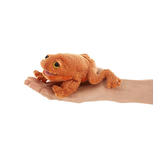 orange toad plush finger puppet help in a hand against a white background