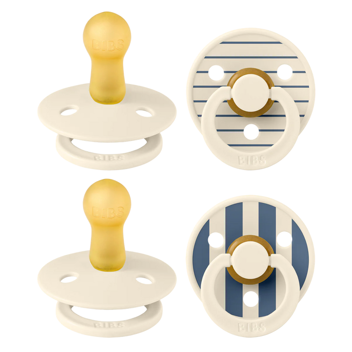 Set of four baby pacifiers with striped and plain designs on a white background