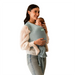 Woman holding a baby in a grey moby baby carrier against a white background
