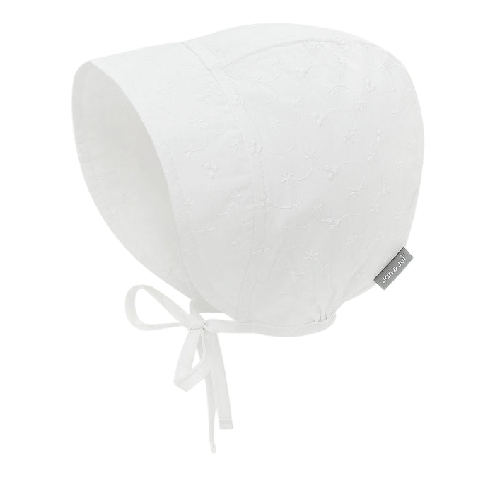 White eyelet baby bonnet with a bow on a white background