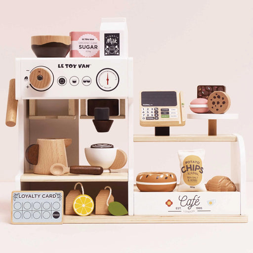 Toy coffee shop set with various items on a white background