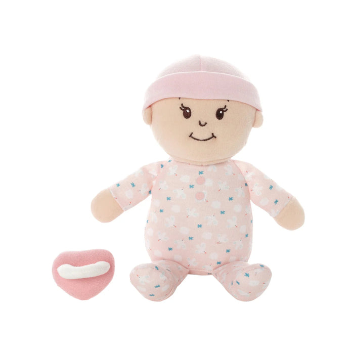 Plush baby doll with pink outfit and pacifier on a white background