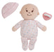 Baby doll with pink outfit, hat, and pacifier on a white background