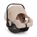 A Nuna baby car seat in a light beige fabric with a black base, shown on a clean white background.