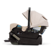 A Nuna baby car seat in a light beige fabric with a black base, shown on a clean white background.