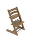 A wooden high chair with a natural oak finish and black metal leg braces, photographed on a seamless white background.