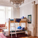 Oeuf Design Bunk bed in a stylish room with a chandelier and decorative wall art.