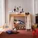 Children playing and reading in room with a lofty wooden bunk bed, colorful bedding, and toys.