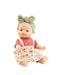 Baby doll wearing a pink shirt and floral overalls with a green headband on a white background