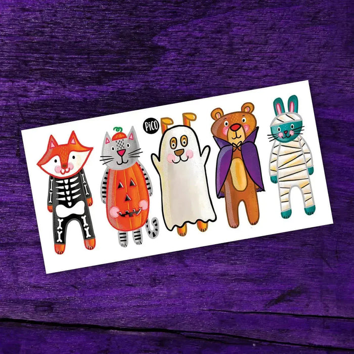 Set of Halloween-themed animal tattoos on a white card with a purple background