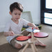 Child playing with a small drum set indoors