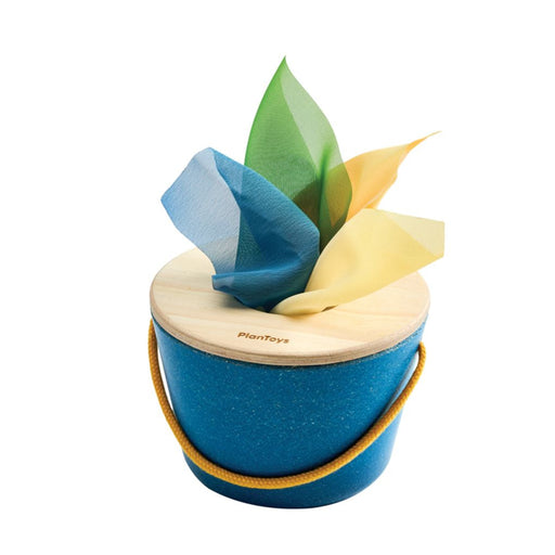 Blue wooden toy with colorful cloth tissues on a white background