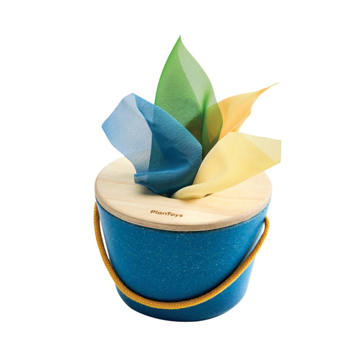 Blue wooden toy with colorful cloth tissues on a white background