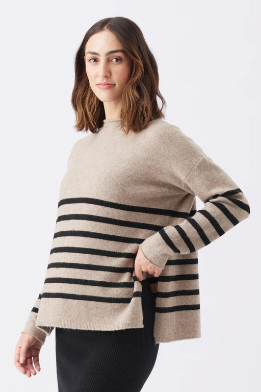 Woman wearing a beige sweater with black horizontal stripes on a white background