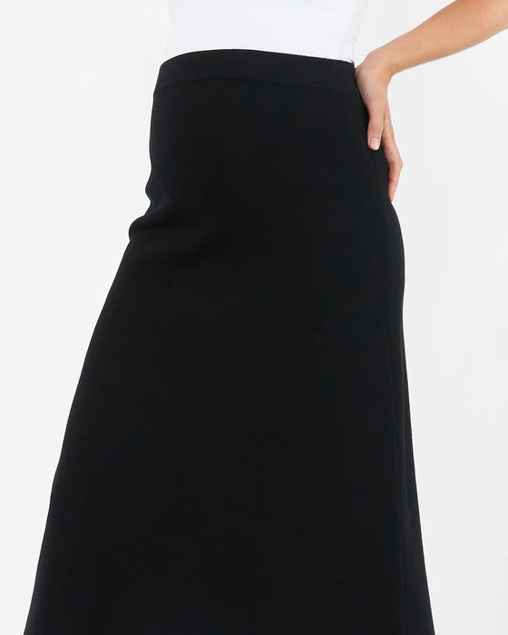 Black skirt worn by a person on a white background