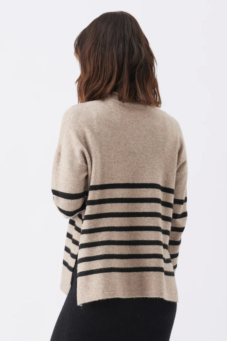 Person wearing a beige sweater with black horizontal stripes on a white background