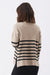 Person wearing a beige sweater with black horizontal stripes on a white background