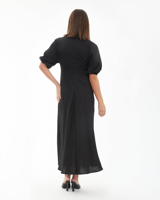 Woman wearing a black dress with a plain white background