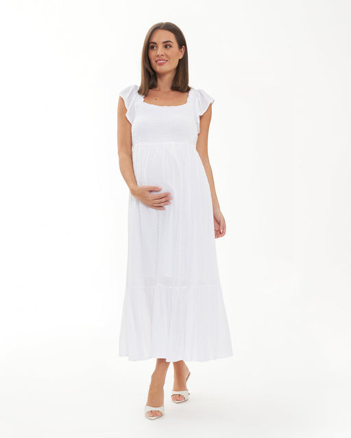 Woman wearing a white maternity dress on a white background