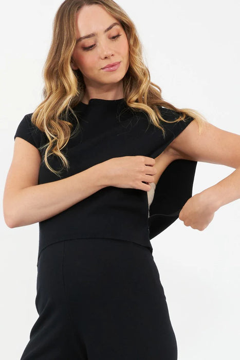Woman wearing a black crop nursing shirt against a white background