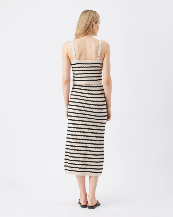 Woman wearing a black and white striped dress on a white background