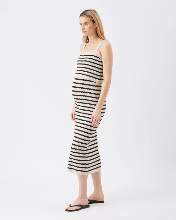 Woman wearing a black and white striped dress on a white background