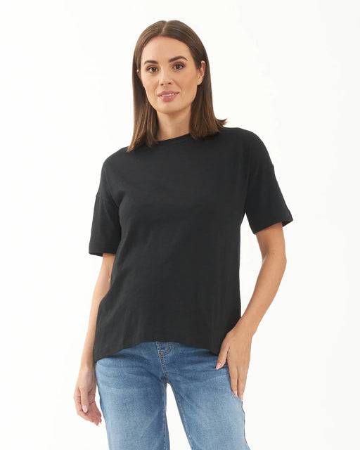 Woman wearing a black t-shirt and blue jeans on a white background