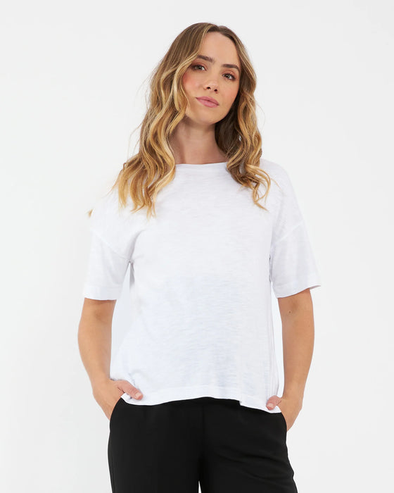 Woman wearing a white t-shirt and black pants on a white background