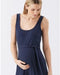 Woman wearing a navy blue sleeveless romper with a belt tie on a white background