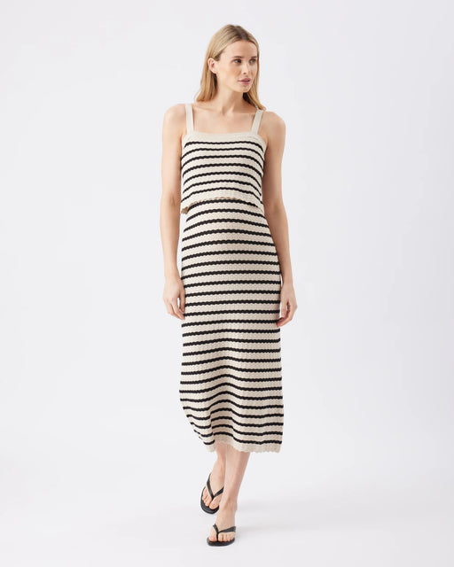 Woman wearing a black and white striped dress on a white background