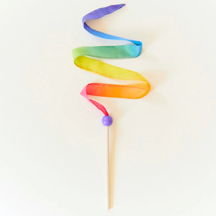 Colorful rainbow silk ribbon on a wooden wand set against a white background
