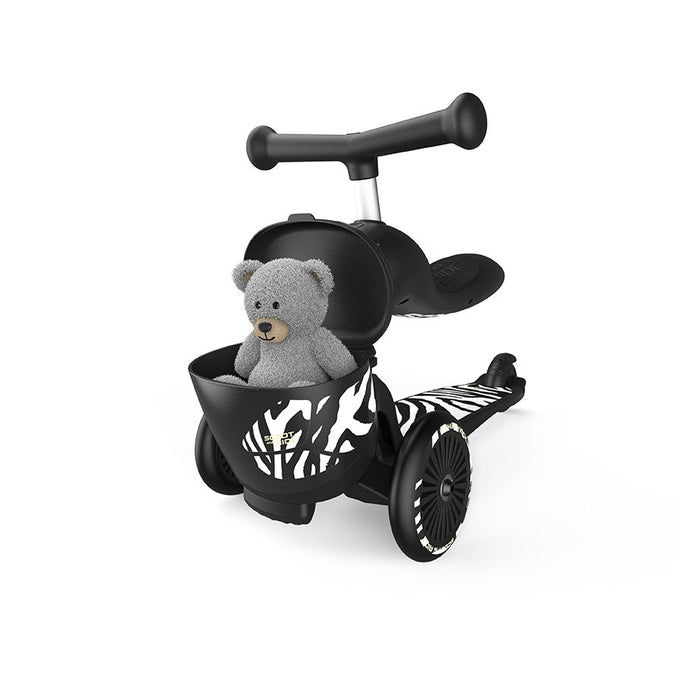 close up of ride on toy in black with zebra striping and place for teddy bear to sit in basket.