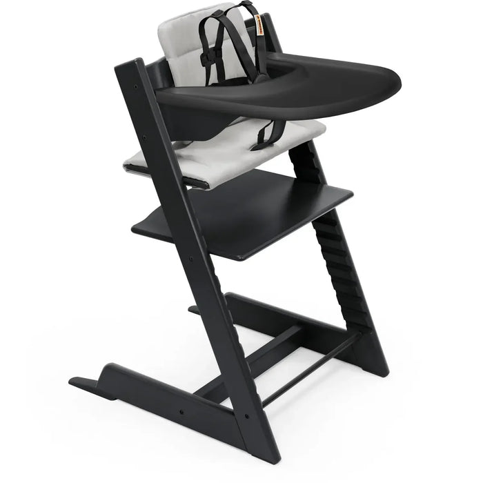 Black Stokke high chair with tray and cushion on a white background