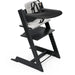Black Stokke high chair with tray and cushion on a white background