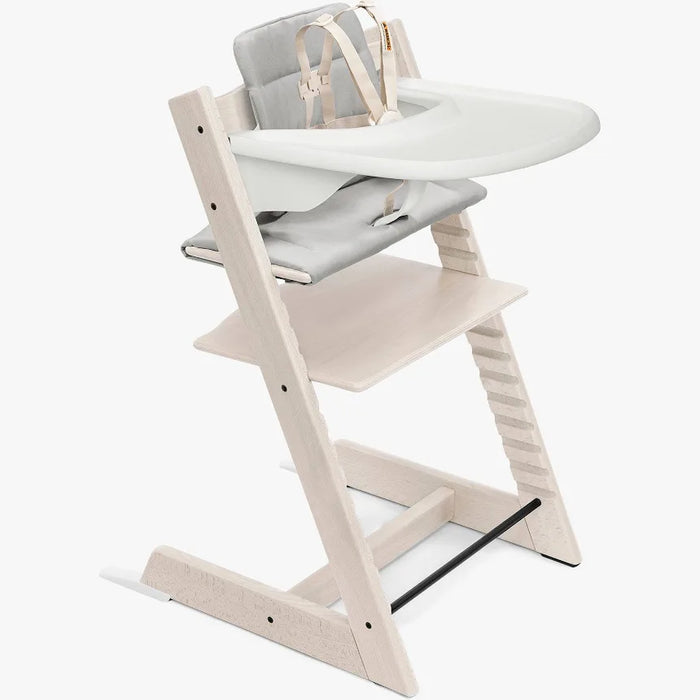 Wooden high chair with a white tray and gray cushion on a white background
